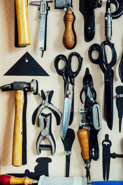 Scissors and tools hanging on wall in arts studio — Stock Photo
