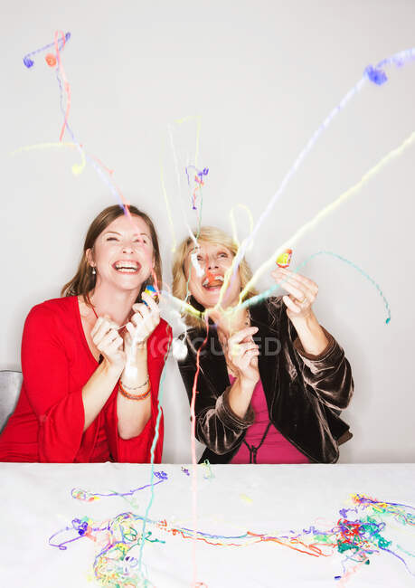 Two women with party poppers — Stock Photo