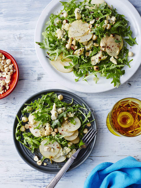Salade de poires fraîches, fromage bleu et noisettes sur table — Photo de stock