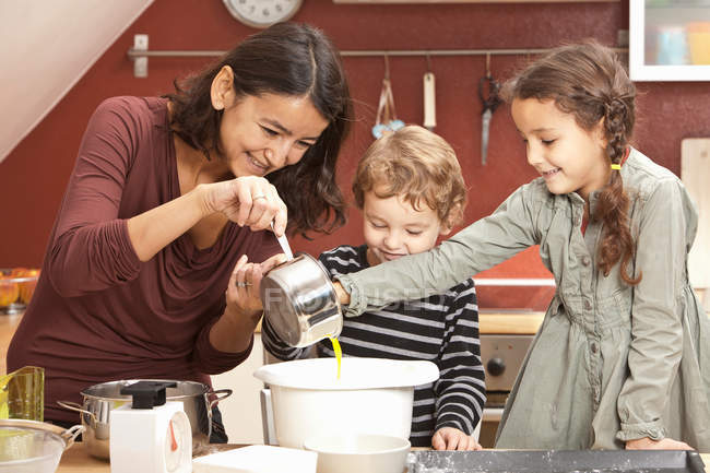 Mamma e bambini cucinano in cucina — Foto stock