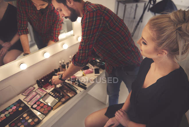 Maschio make up artist selezionando make up per servizio fotografico — Foto stock