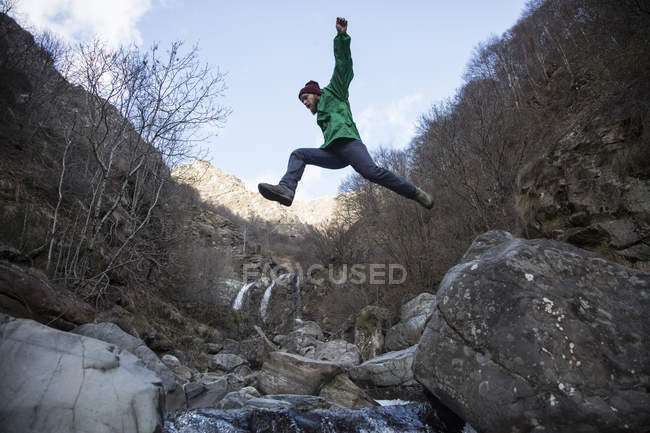 Uomo che salta sopra il fiume Toce, Premosello, Verbania, Piemonte, Italia — Foto stock