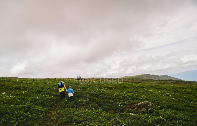 Rear view of father and daughter hiking in landscape, Ural Mountains, Russia — Stock Photo