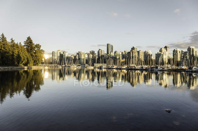 Vista del horizonte de la ciudad y el puerto deportivo al atardecer, Vancouver, Canadá - foto de stock
