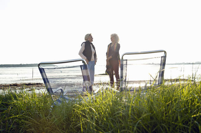 Mãe e filha conversando na praia à luz do sol — Fotografia de Stock