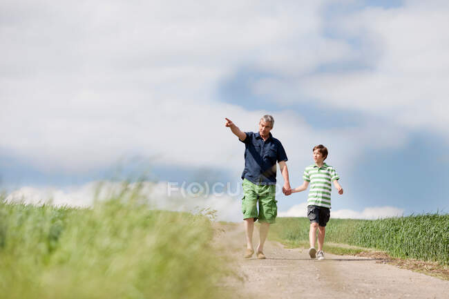 Father and son walking down a road — Stock Photo