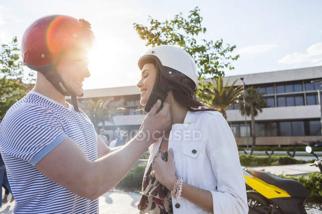 Young man fastening girlfriend's crash helmet, Split, Dalmatia, Croatia — Stock Photo