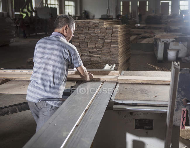 Carpenter working on wooden planks in factory, Jiangsu, China — Stock Photo
