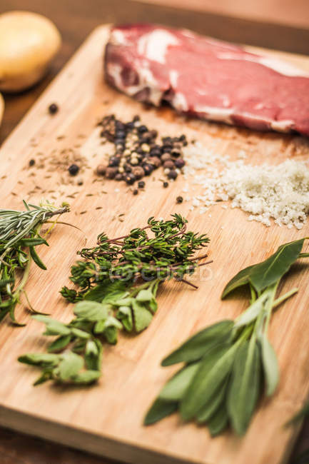 Board laid with meat and seasonings — Stock Photo