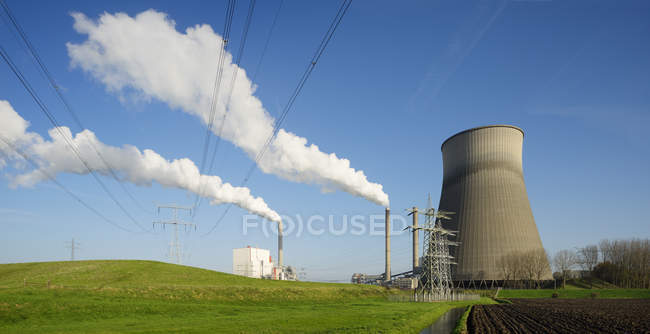 Ploughed field in front of power station — Stock Photo