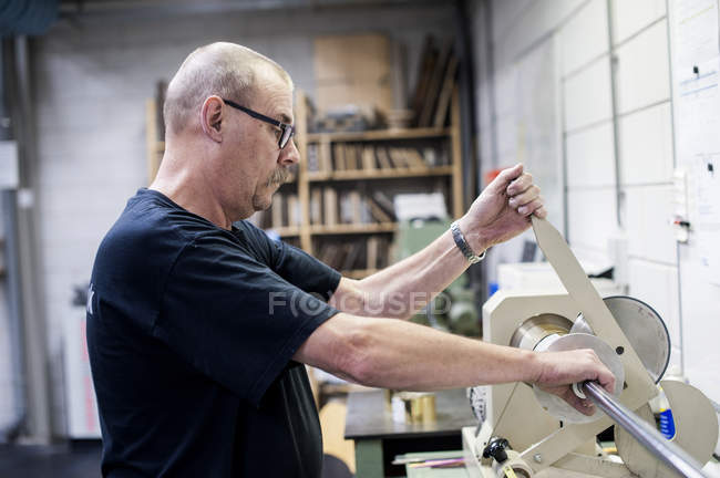 Worker operating cutting machine in paper printing workshop — Stock Photo