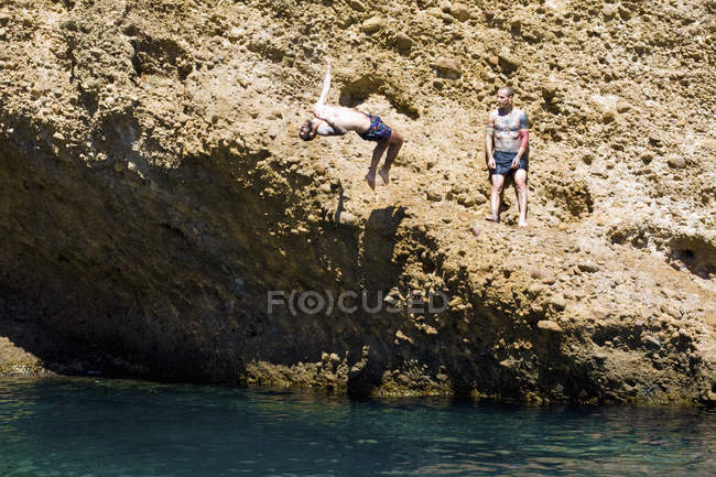 Zwei junge männer, die von felsen ins meer tauchen, marseille, franz — Stockfoto