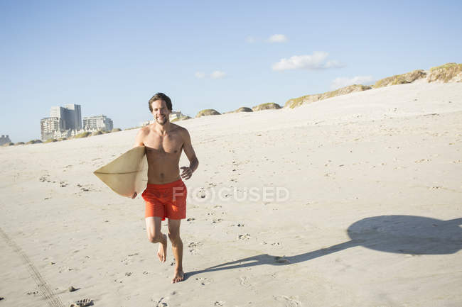 Молоді чоловіки серфер працює на пляжі, Кейптаун, Західної Капській провінції, Південна Африка — стокове фото