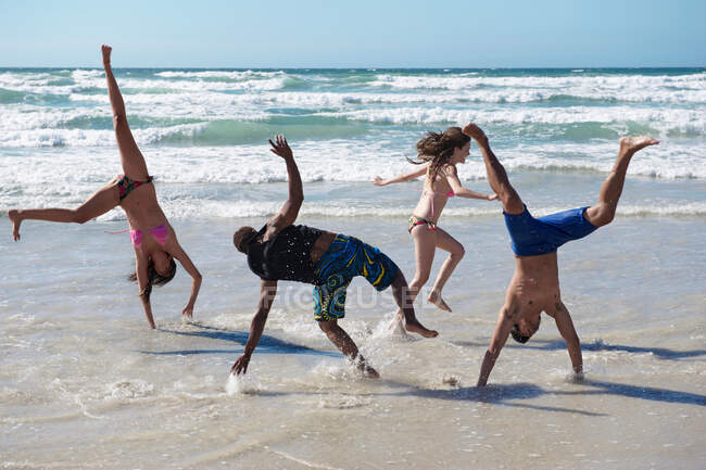 Молодая группа резвится на пляже — стоковое фото