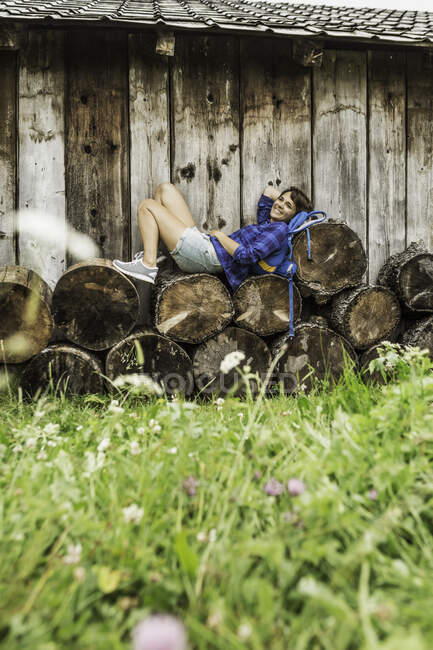 Donna che riposa su pila di tronchi tagliati — Foto stock