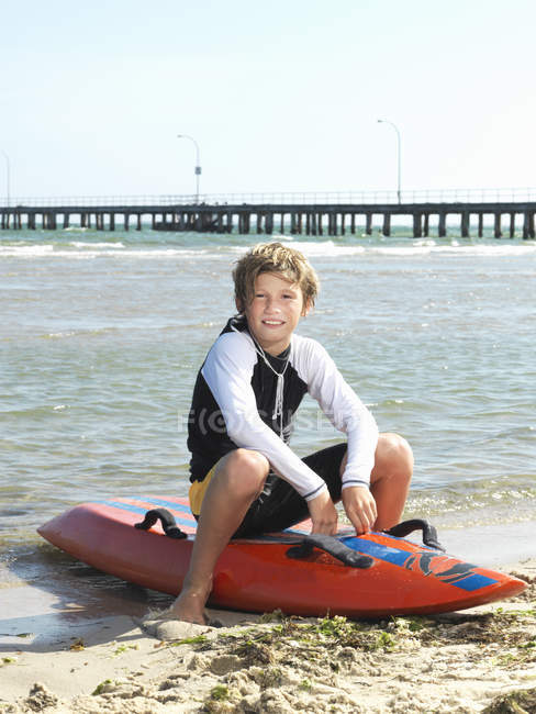 Retrato de menino nipper (criança salva-vidas surf) sentado na prancha de surf, Altona, Melbourne, Austrália — Fotografia de Stock