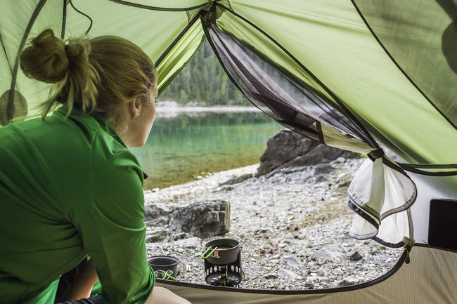 Woman in tent by water, Leermoos, Tyrol, Austria — Stock Photo