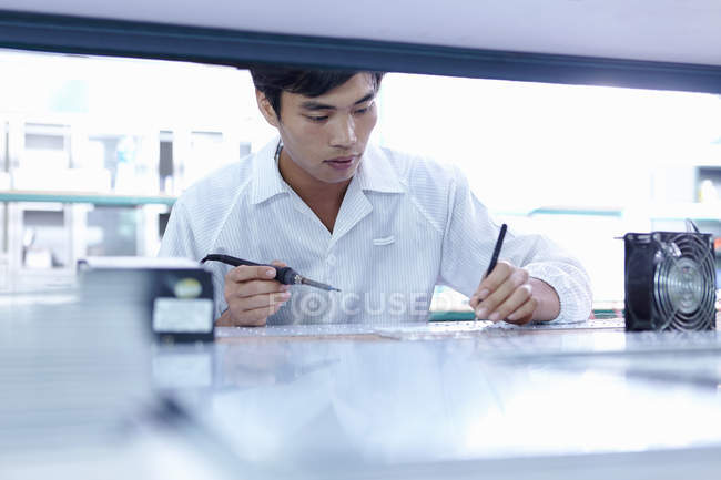 Young male technician working in LED factory in Guangdong, China — Stock Photo