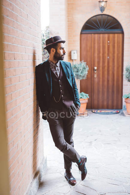 Young man leaning against brick wall — Stock Photo