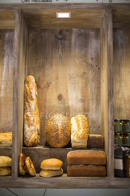 Panes frescos, bollos de pan y baguette en bandeja de panadería - foto de stock