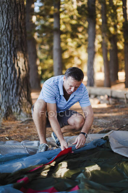 Mann baut Zelt auf Campingplatz auf — Stockfoto