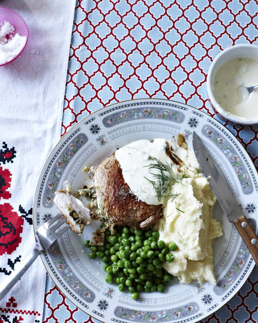 Still life with plate of pork cutlets, mashed potatoes and peas — Stock Photo