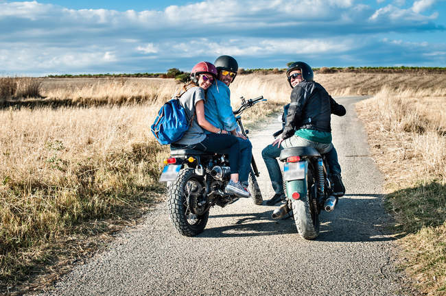 Vista trasera de tres amigos en motocicletas en carretera rural, Cagliari, Cerdeña, Italia - foto de stock