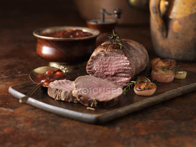 Venison rump with mulled winter fruit sauce and red onions — Stock Photo