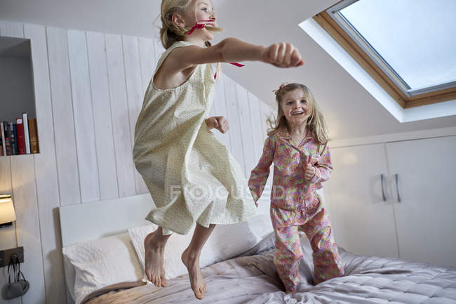 Девушки прыгают на кровати в лофт-комнате — стоковое фото