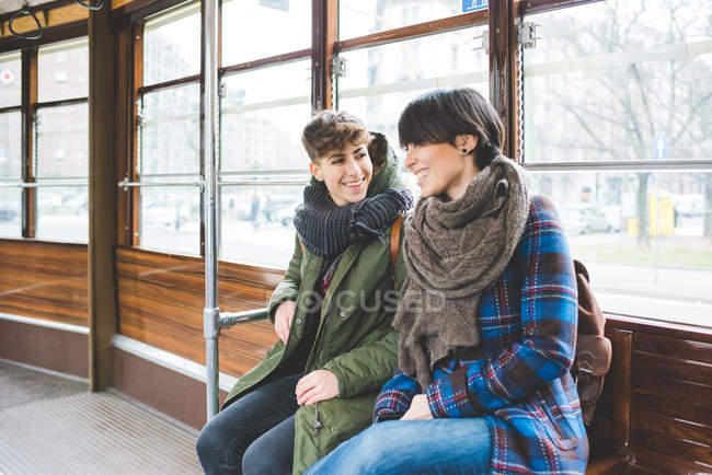 Due sorelle donne sedute sulla funivia, sorridenti — Foto stock