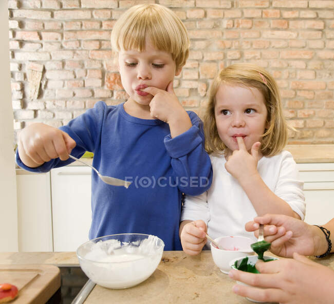 Дівчина, хлопчик дегустація інгредієнтів випічки — стокове фото