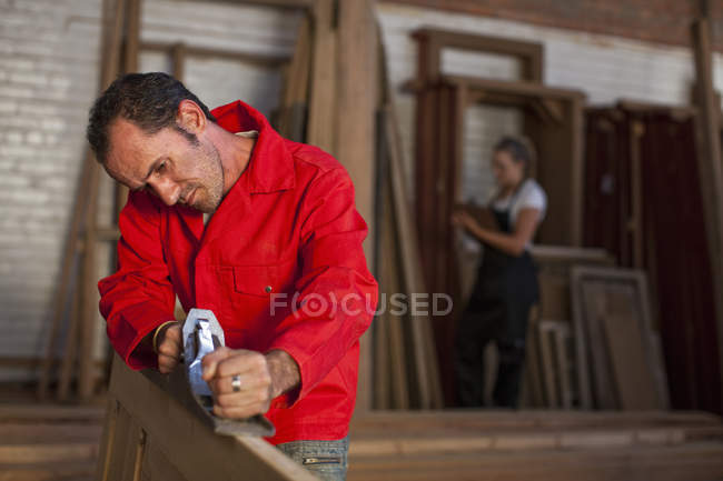 Carpenter using plane at carpentry — Stock Photo