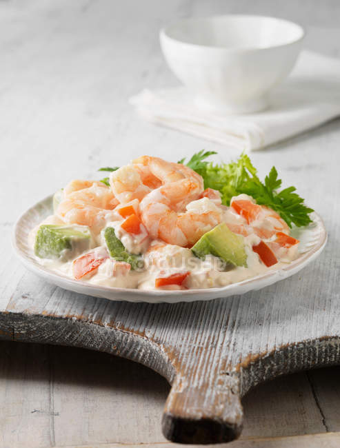 Plate of boiled prawns and avocado with sauce and parsley — Stock Photo
