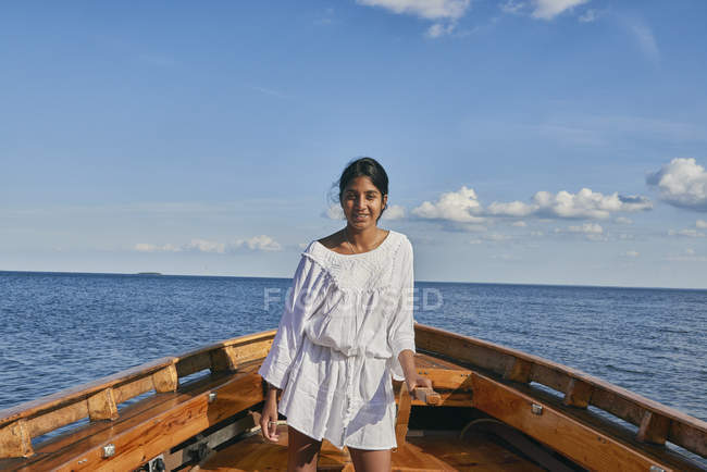 Giovane donna su una barca nell'oceano blu — Foto stock