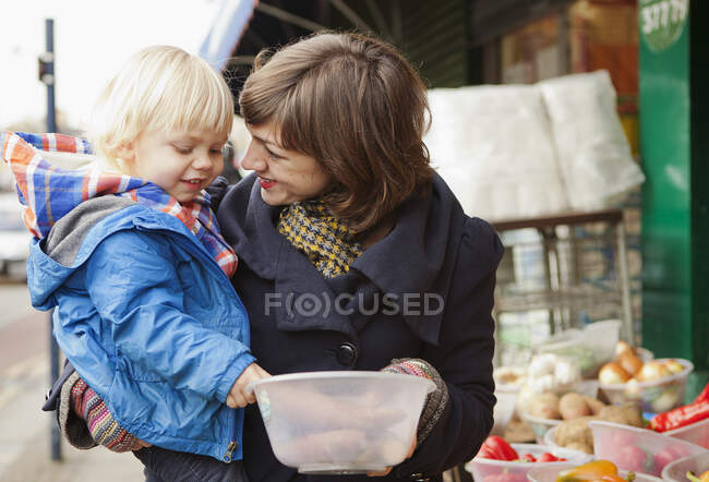 Mother and son shopping at street market stall — Stock Photo