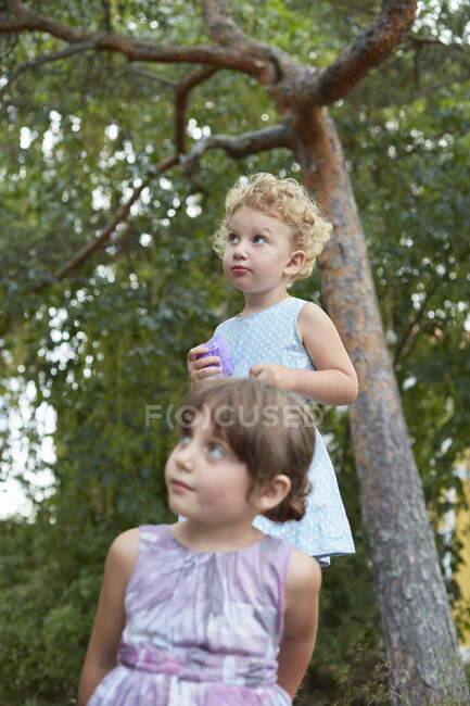 Retrato franco de dos hermanas jóvenes mirando hacia arriba - foto de stock