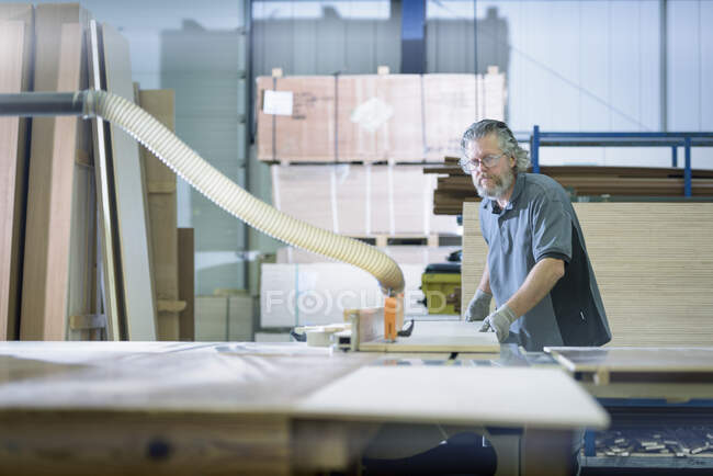 Arbeiter sägt Holz in Wohnmobilfabrik — Stockfoto