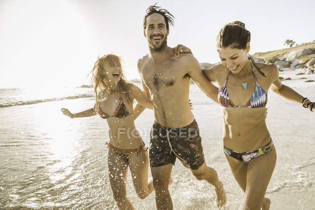 Three mid adult friends splashing in sea, Cape Town, South Africa — Stock Photo