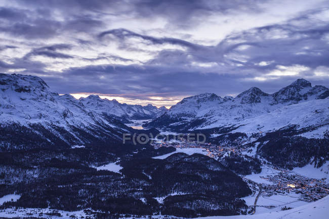 Montagne rocciose innevate sotto il cielo nuvoloso al tramonto — Foto stock