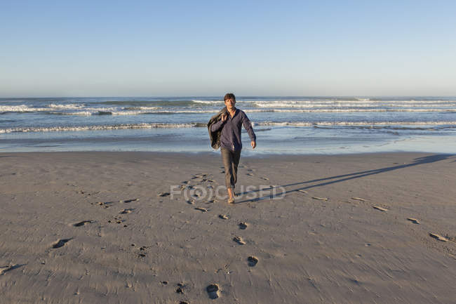 Homme marchant sur la plage — Photo de stock