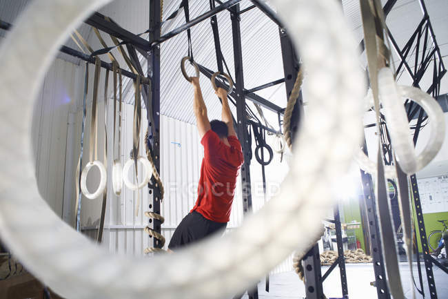 Rear view of athlete doing workout on gymnastic rings — Stock Photo