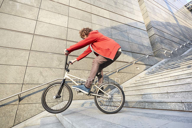 Человек на BMX по ступенькам в городской местности — стоковое фото