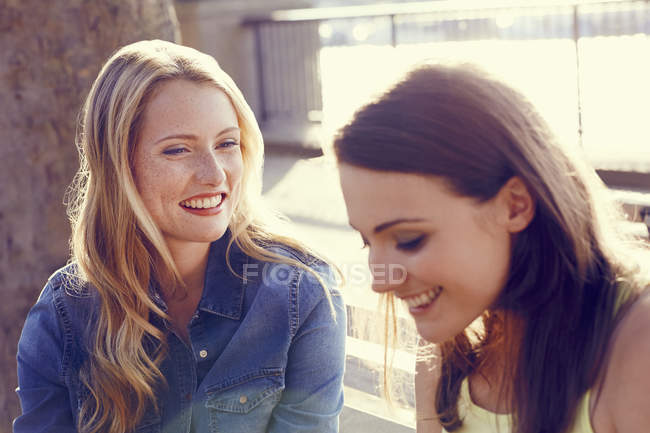 Dos hermosas mujeres hablando bajo el sol - foto de stock