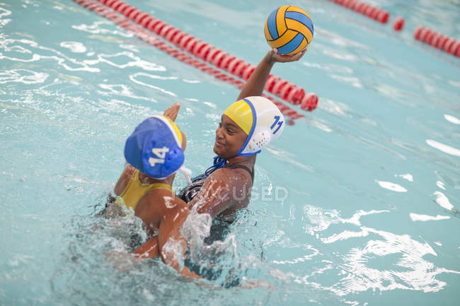 Meninas jogando pólo aquático na piscina esportiva — Fotografia de Stock