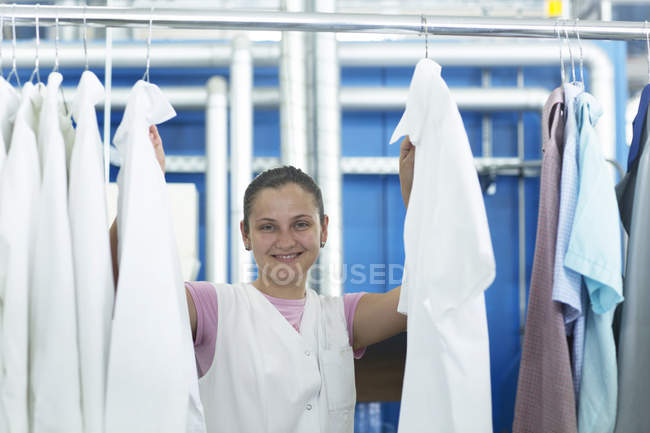 Frau in Waschsalon hängt Wäsche auf — Stockfoto