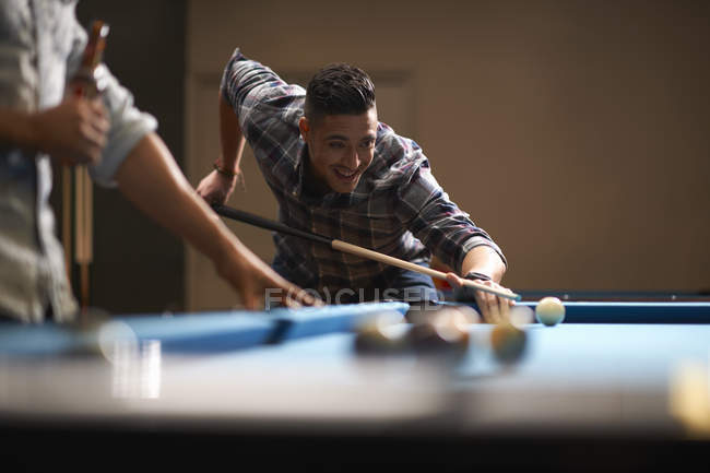 Man playing pool, friend with beer in foreground — Stock Photo