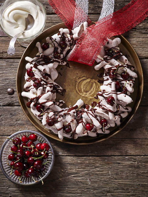 Chocolate meringue wreath with cherries — Stock Photo