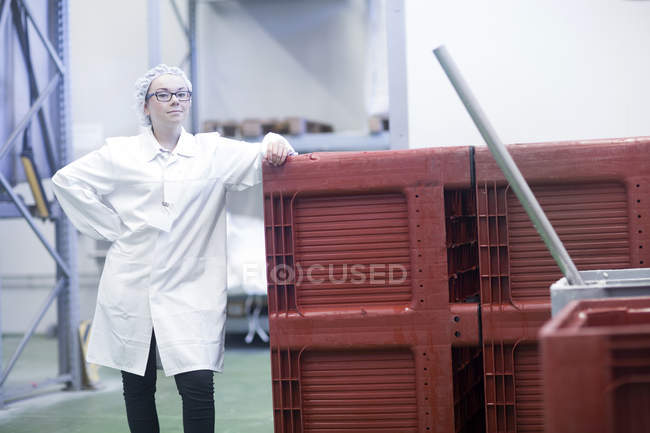 Fabrikarbeiter mit Overall und Haarnetz blickt in die Kamera — Stockfoto