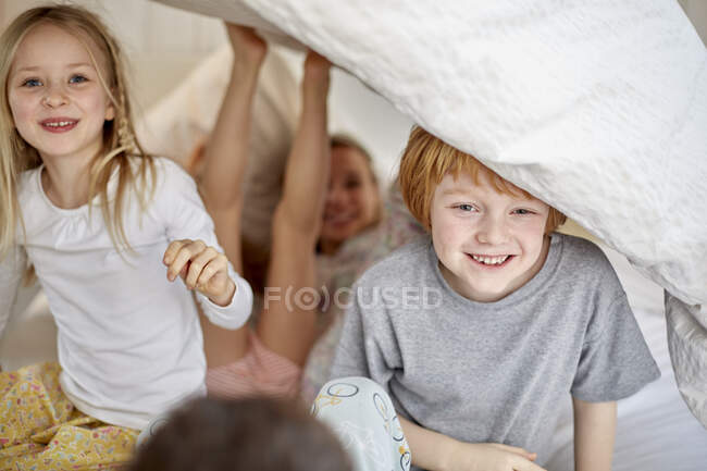 Діти розважаються граючи в ліжку — стокове фото