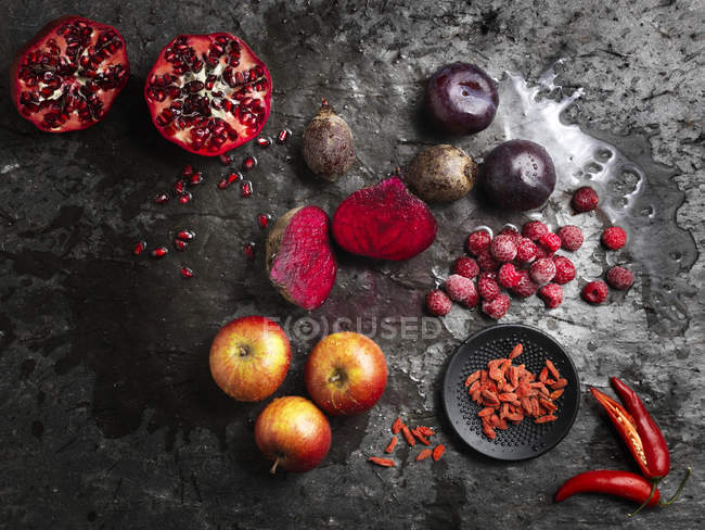 Top view of halved beetroots and fruit on dark background — Stock Photo